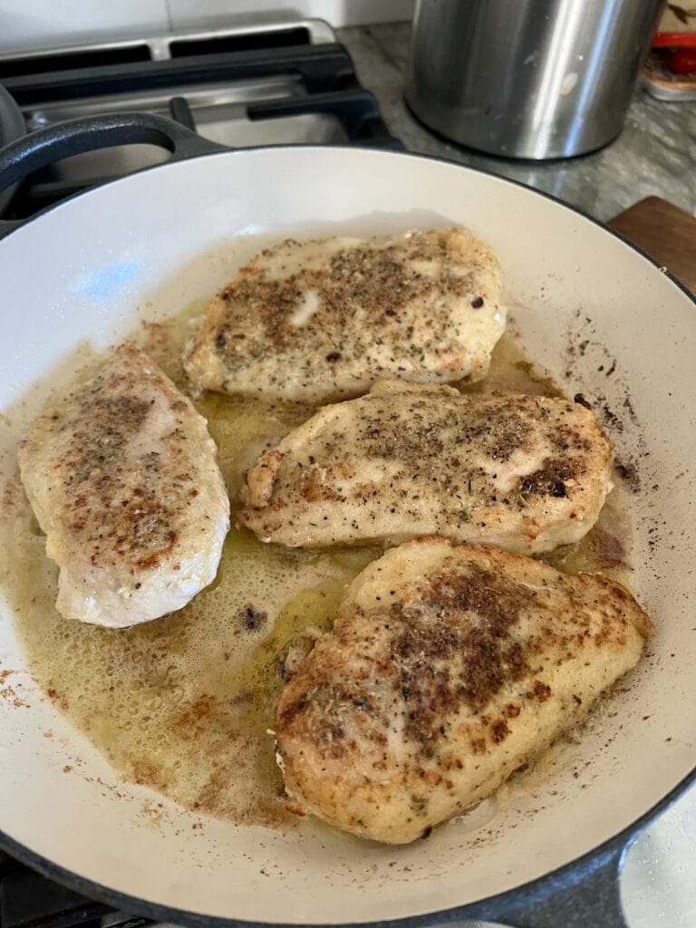 Chicken breast browning in pan.