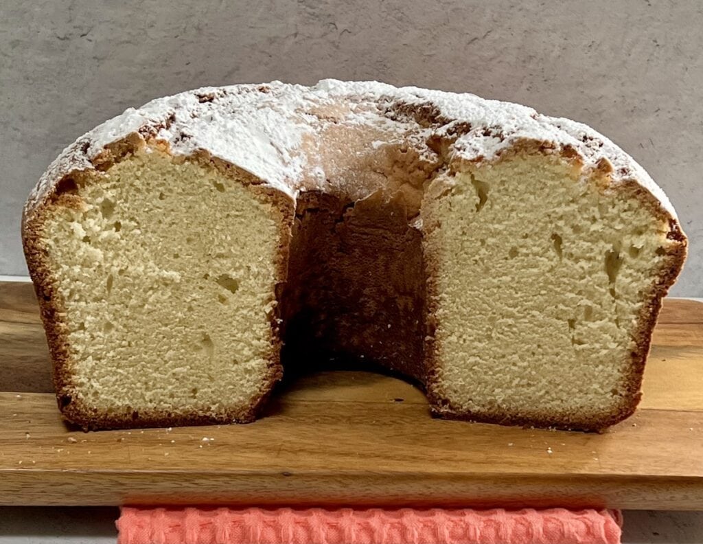 Half of sour cream pound cake on cutting board.
