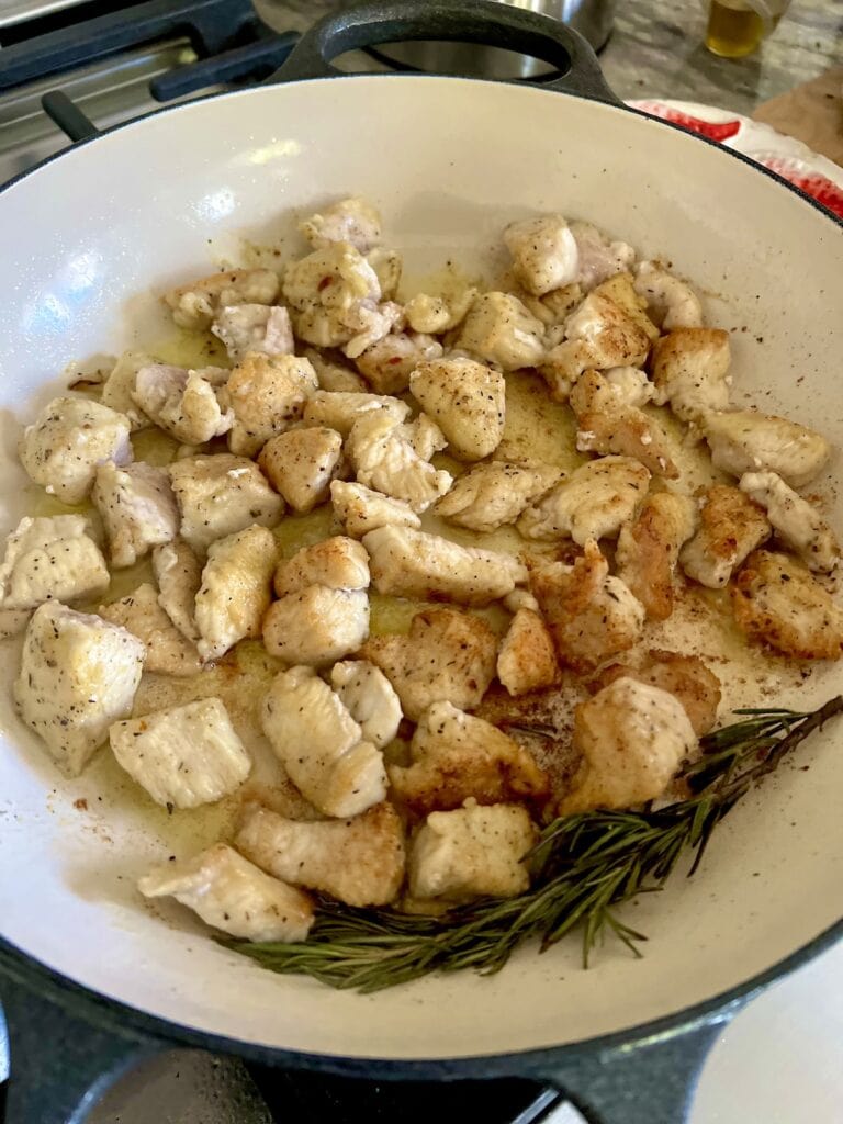Browned chicken in pan.