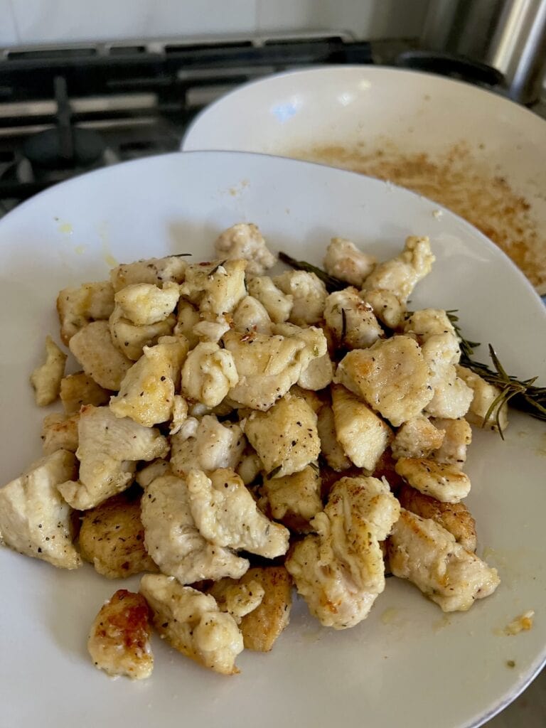 Cooked chicken pieces on plate. transferred out of pan.