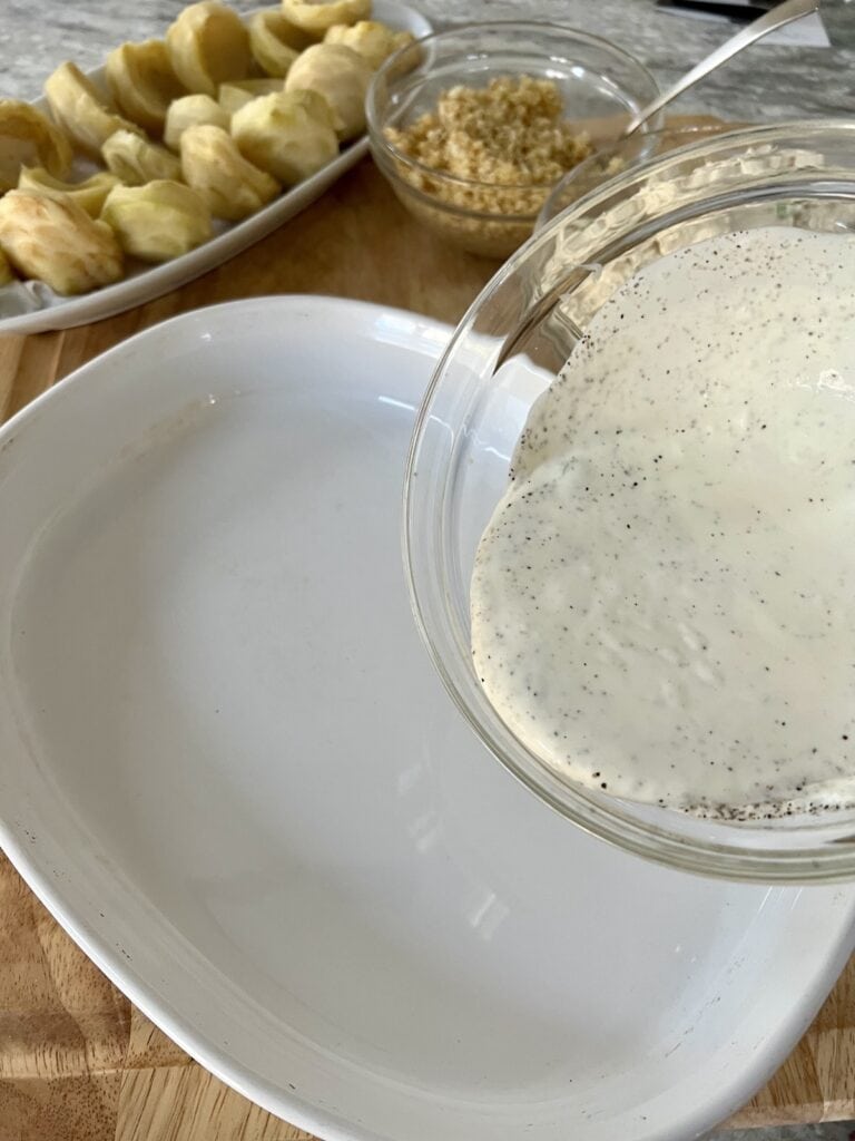Pouring wine/cream mixture into baking dish.