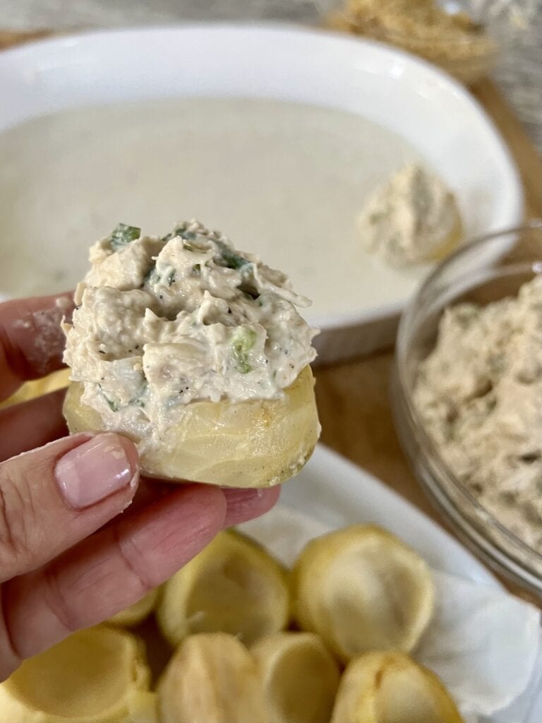 Close up of one crab stuffed artichoke bottom before baking.