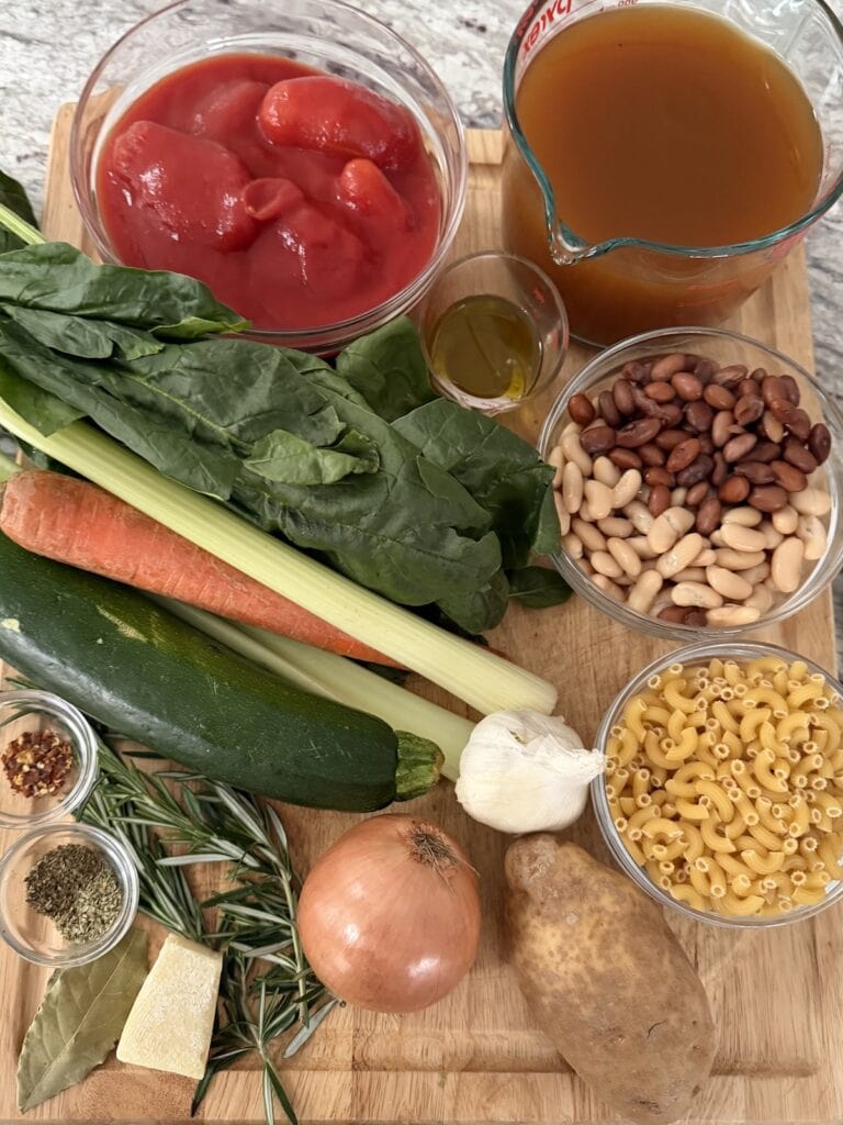 All ingredients for vegetarian minestrone soup on cutting board.