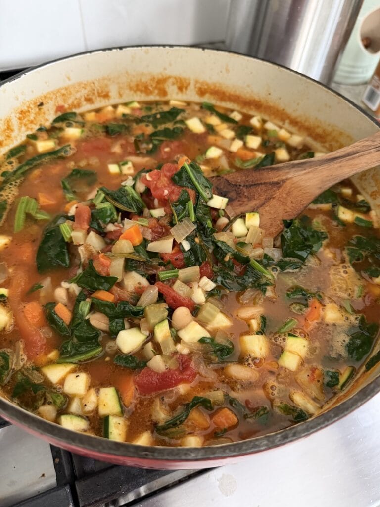 Stirring all ingredients in Dutch oven with wooden spatula.