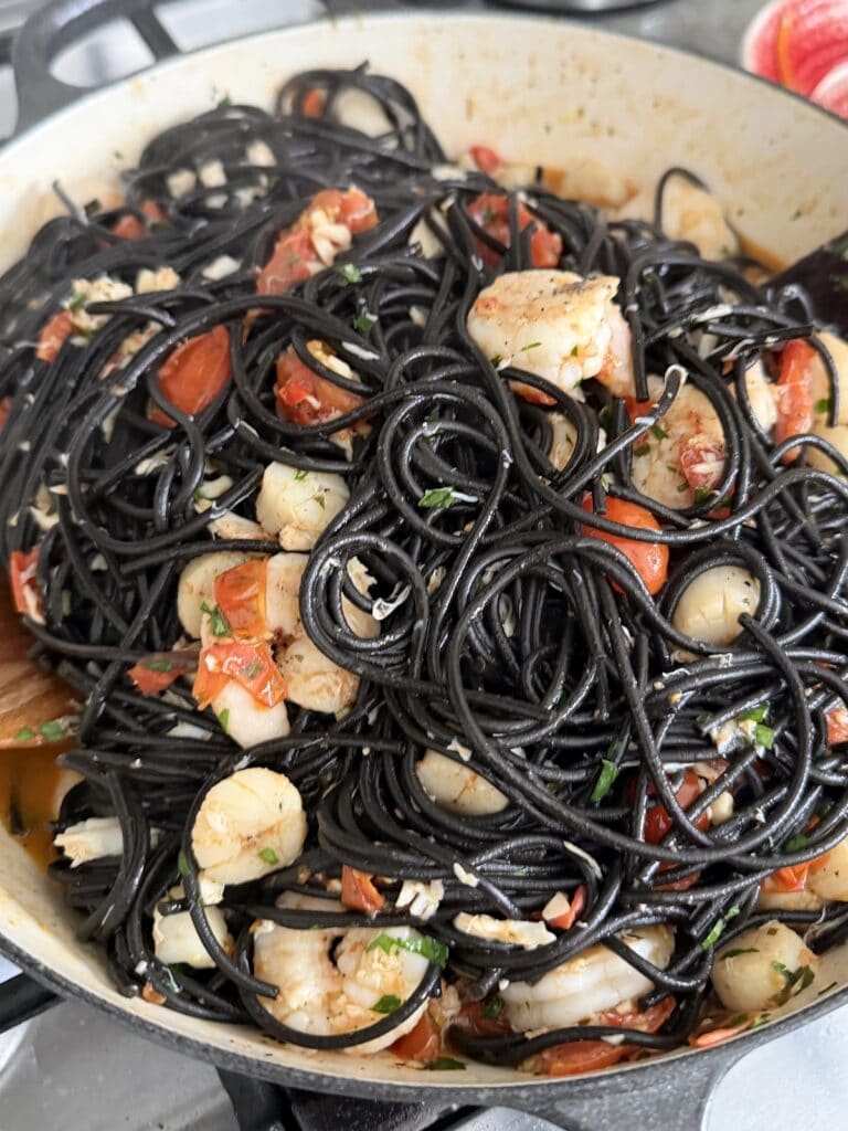 Close up of finished Spaghetti Frutti Di Mare made with nero di seppia spaghetti .