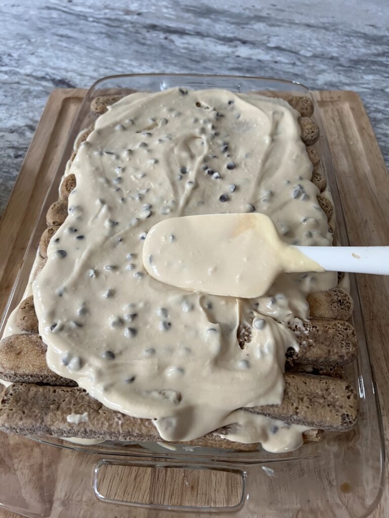 Spreading out the creamy top layer with rubber spatula.
