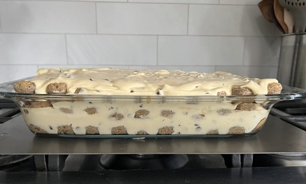 Layered Tiramisu Classico in glass dish ready to be refrigerated for awhile.