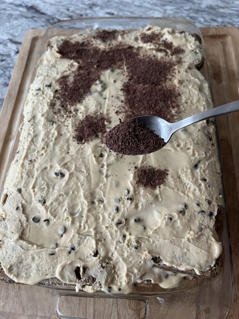 Sprinkling shaved chocolate over the tiramisu.