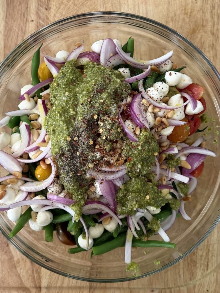 All ingredients for Italian green bean salad in bowl ready to be mixed.