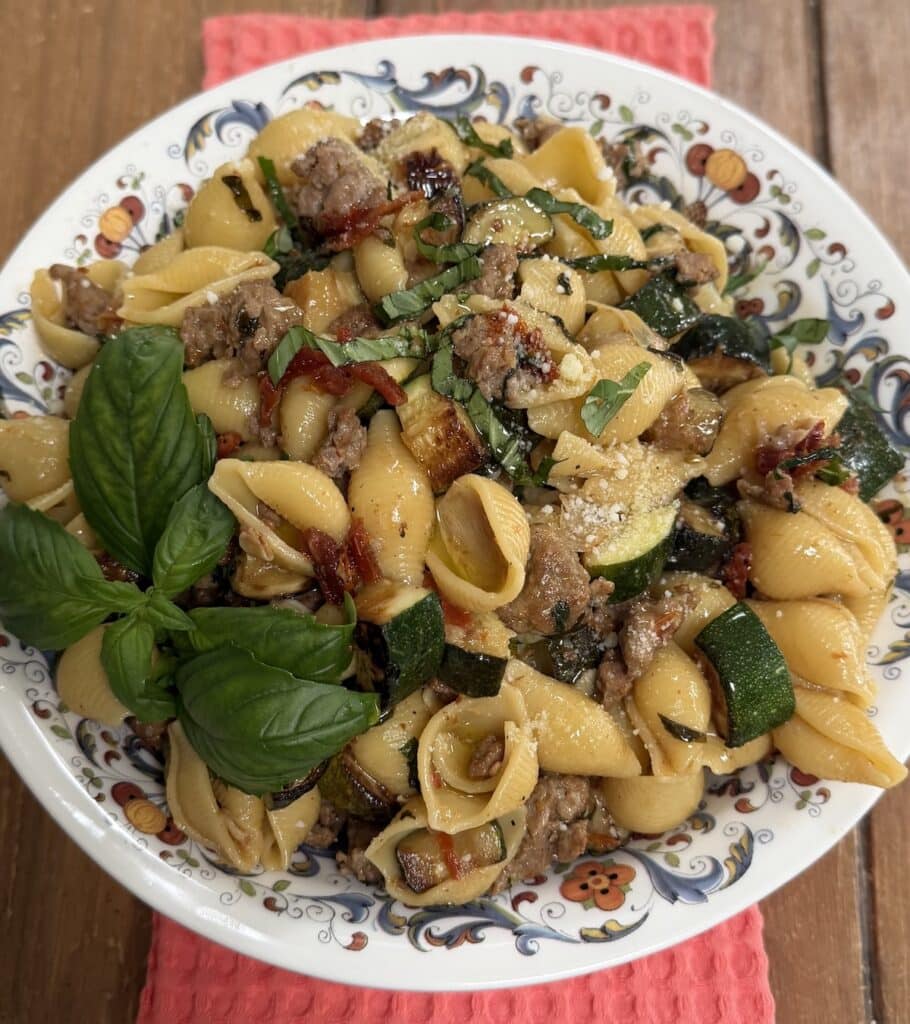 Sausage Zucchini Pasta in decorative bowl with basil garnish.