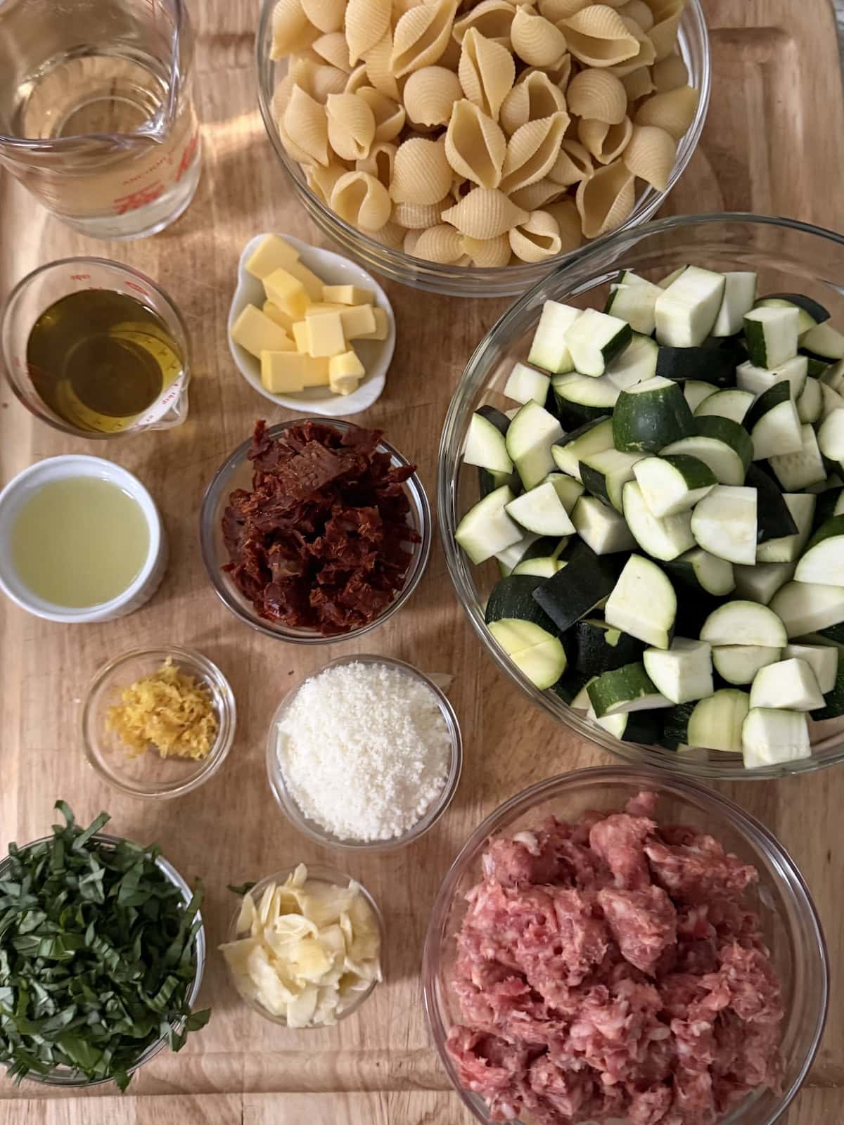 All prepped ingredients for Italian Sausage and Zucchini Pasta  on cutting board.