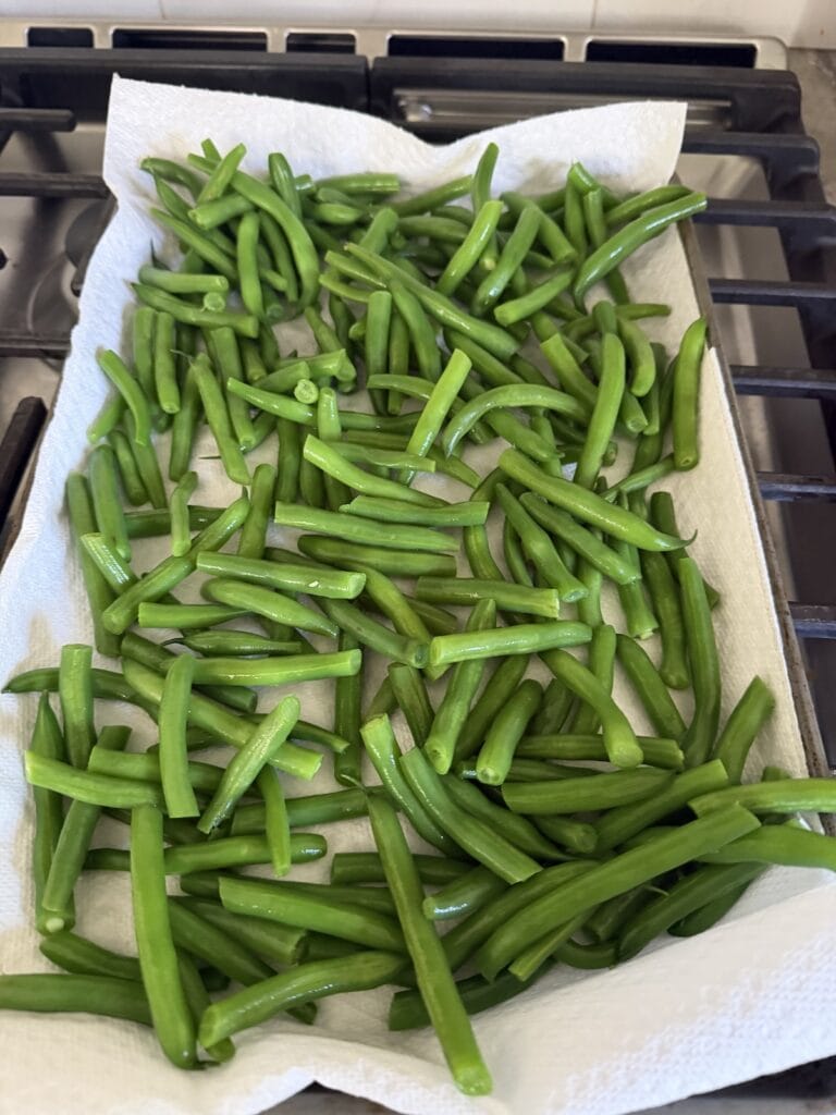 Laying out the blanched string beans on paper towels to dry.