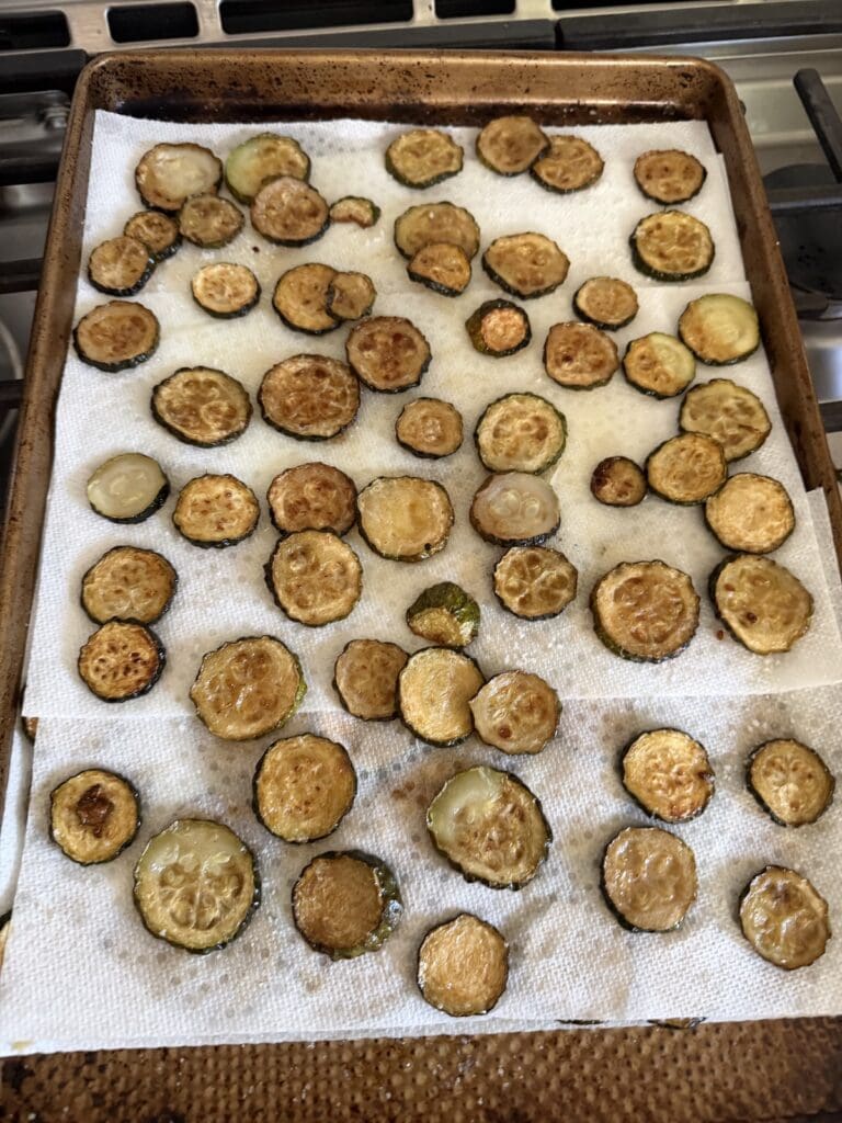 The fried zucchini slices on paper towels after frying.