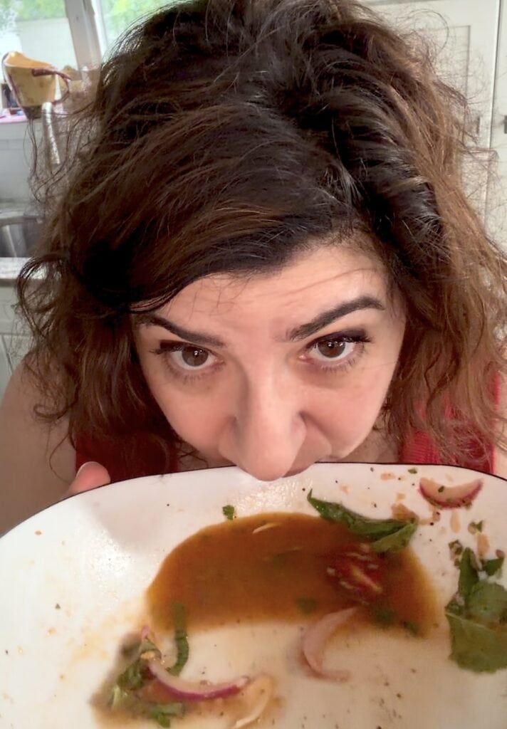 Michele drinking the remaining tomato juice from bowl.
