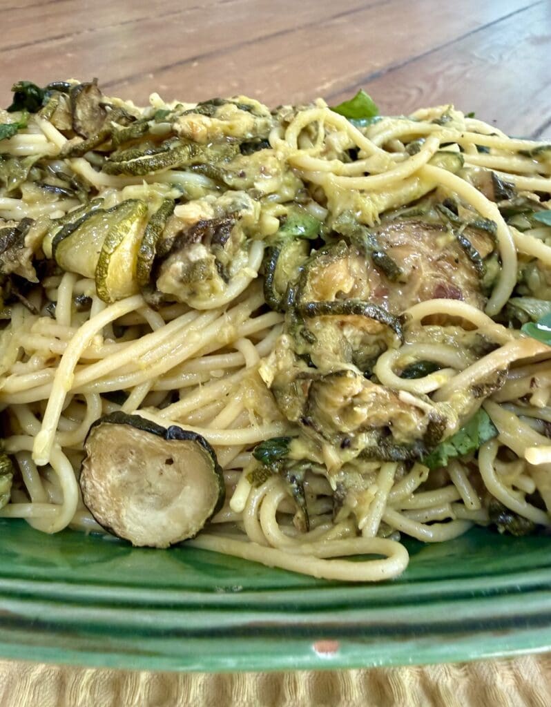 Side view of Italian Zucchini Pasta piled high in green serving platter.