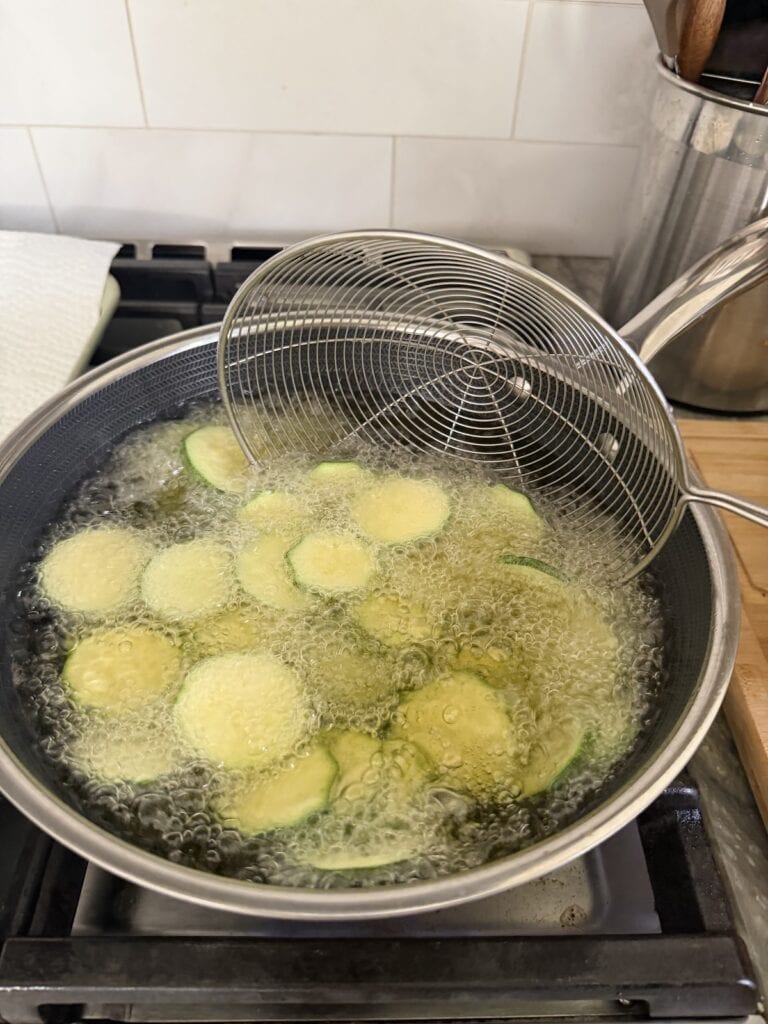 Frying the zucchini in hot oil for Pasta Alla Nerano.