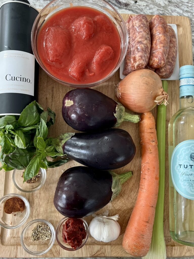 All ingredients for eggplant sausage ragu on cutting board.