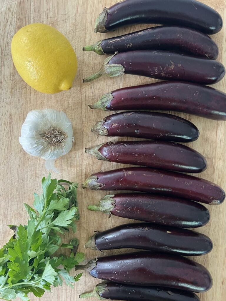All ingredients for roasted baby eggplant on cutting board.