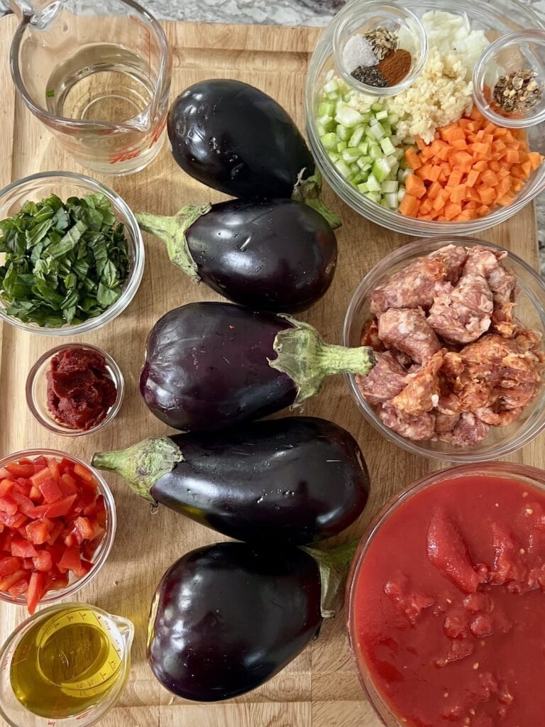 All ingredients for eggplant and beef meatballs on cutting board.