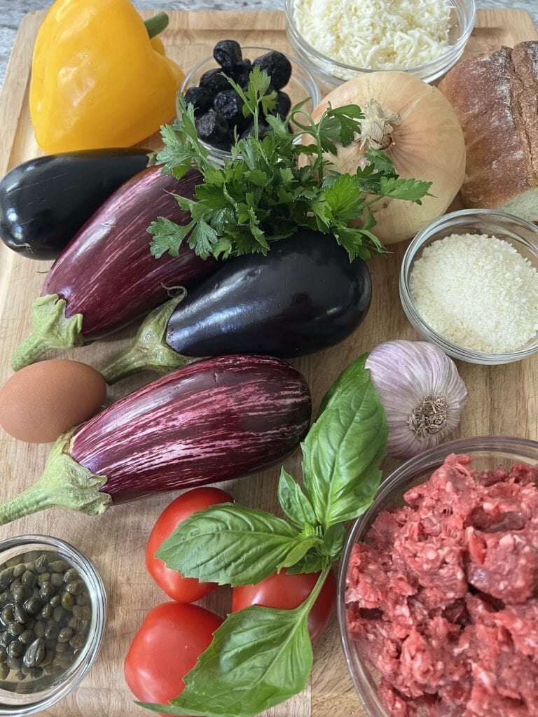 All ingredients for eggplant beef meatballs on cutting board.