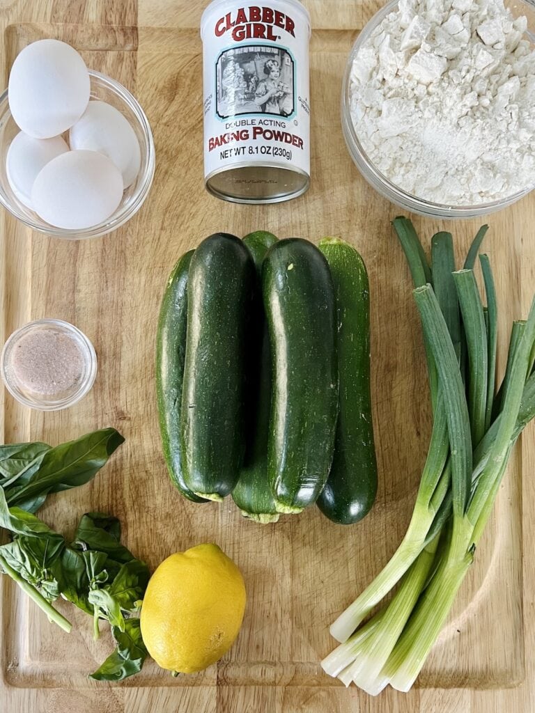 All ingredients for Italian Zucchini fritters on cutting board.