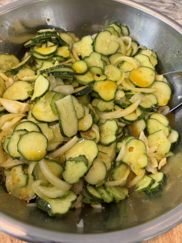 The refrigerator bread and butter pickles in large bowl in brine cooling.