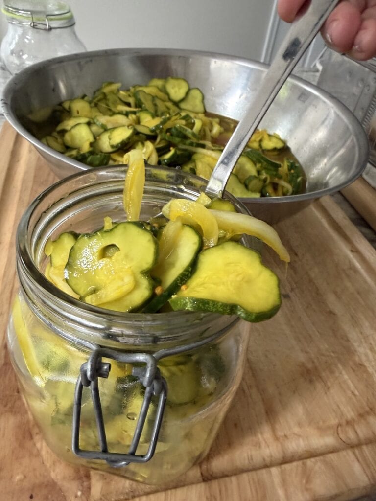 Transferring the cooled refrigerator pickles into a jar.
