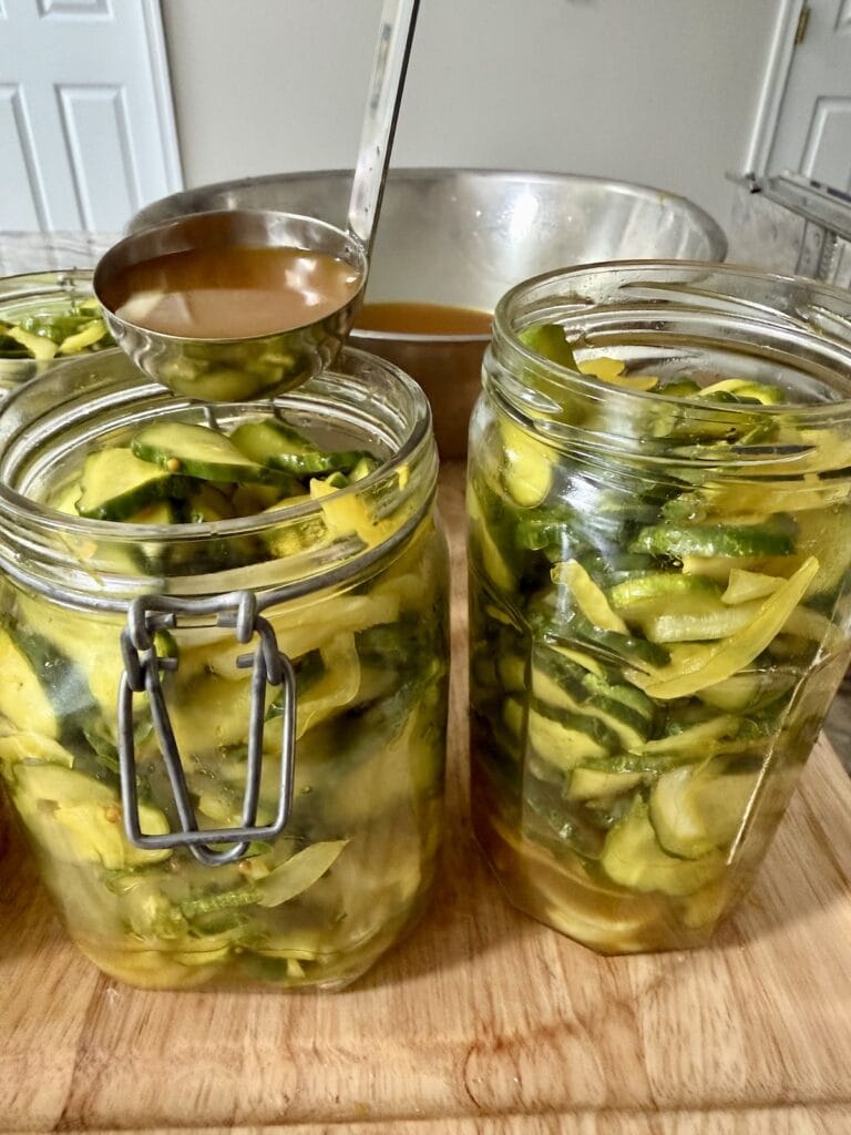 Spooning brine into jars of quick refrigerator pickles.