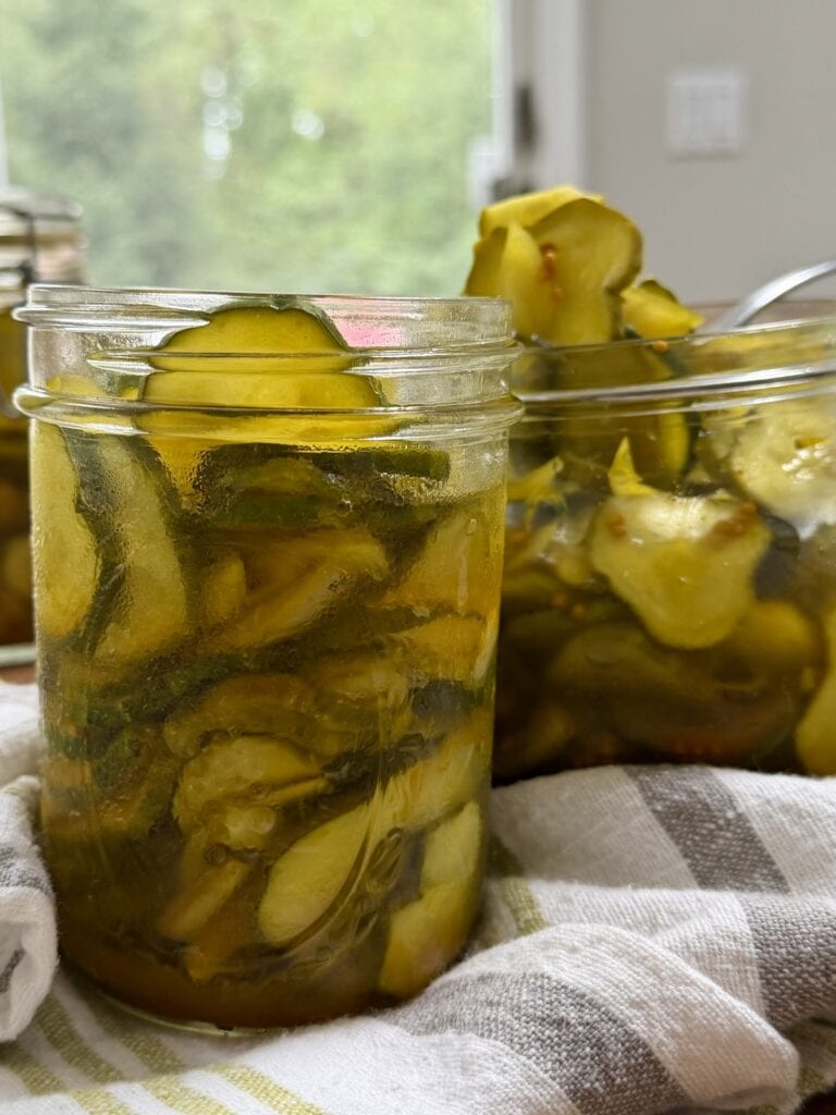 Refrigerator pickles in jar with a second jar in the background.