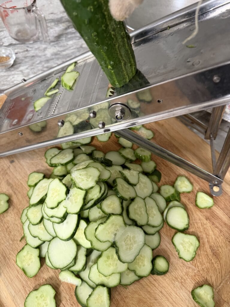 Slicing cucumbers on mandoline.