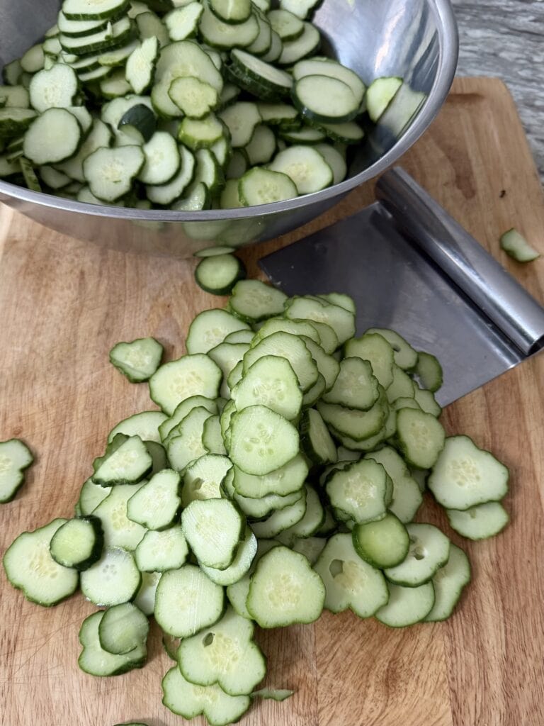 Placing sliced cucumbers into large bowl.