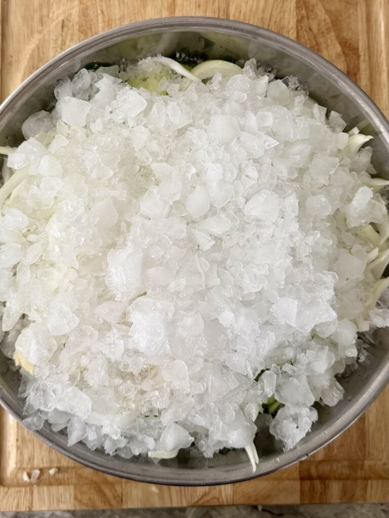 Crushed ice covering the tip layer of the cucumber onion mixture for refigerator bread and butter pickles.