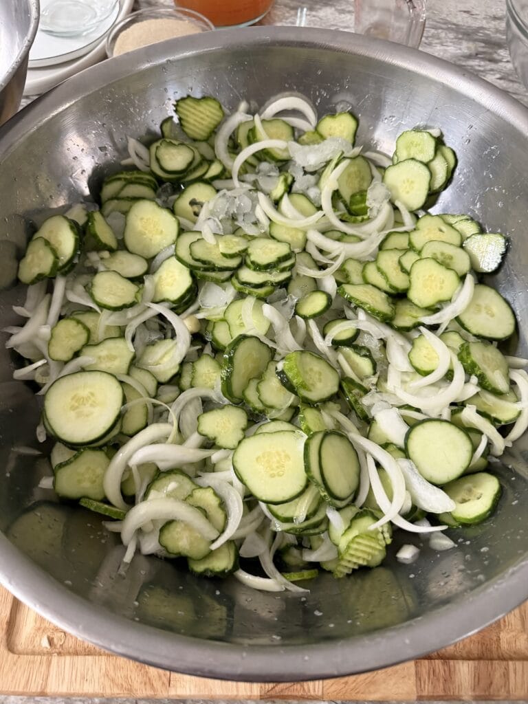The ice mixed into the cucumbers and onions in large bowl.