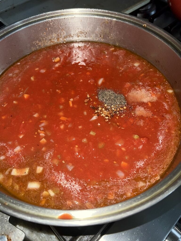 Tomatoes and seasonings added to pot.