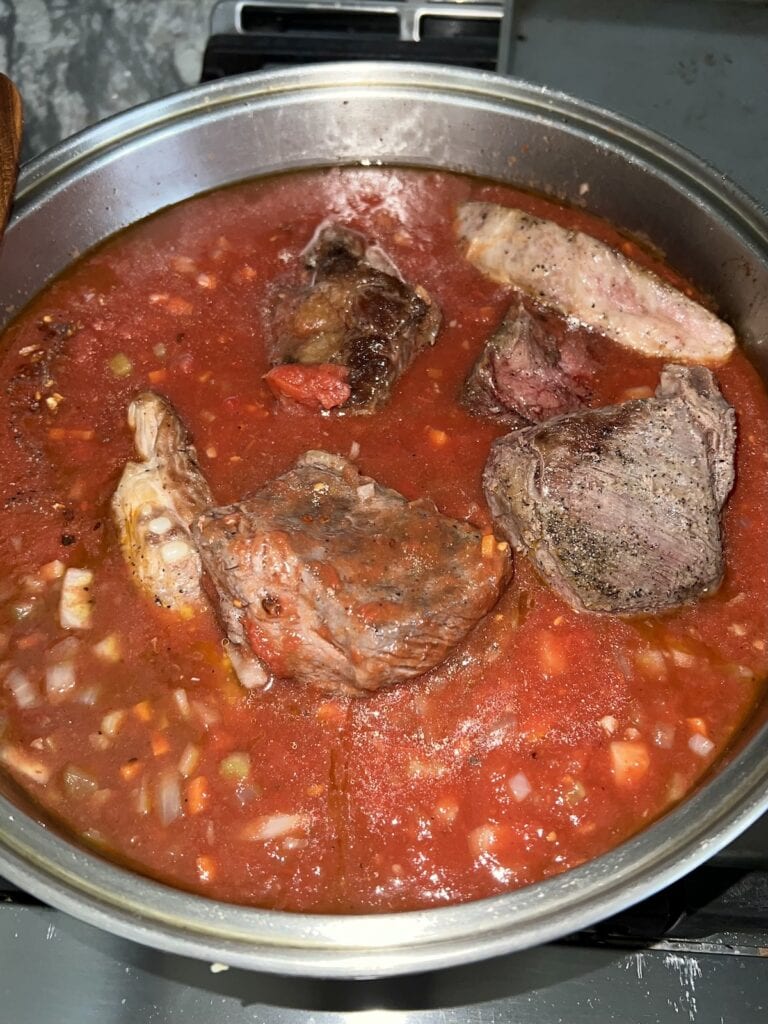 Seared meat pieces added back to pot.