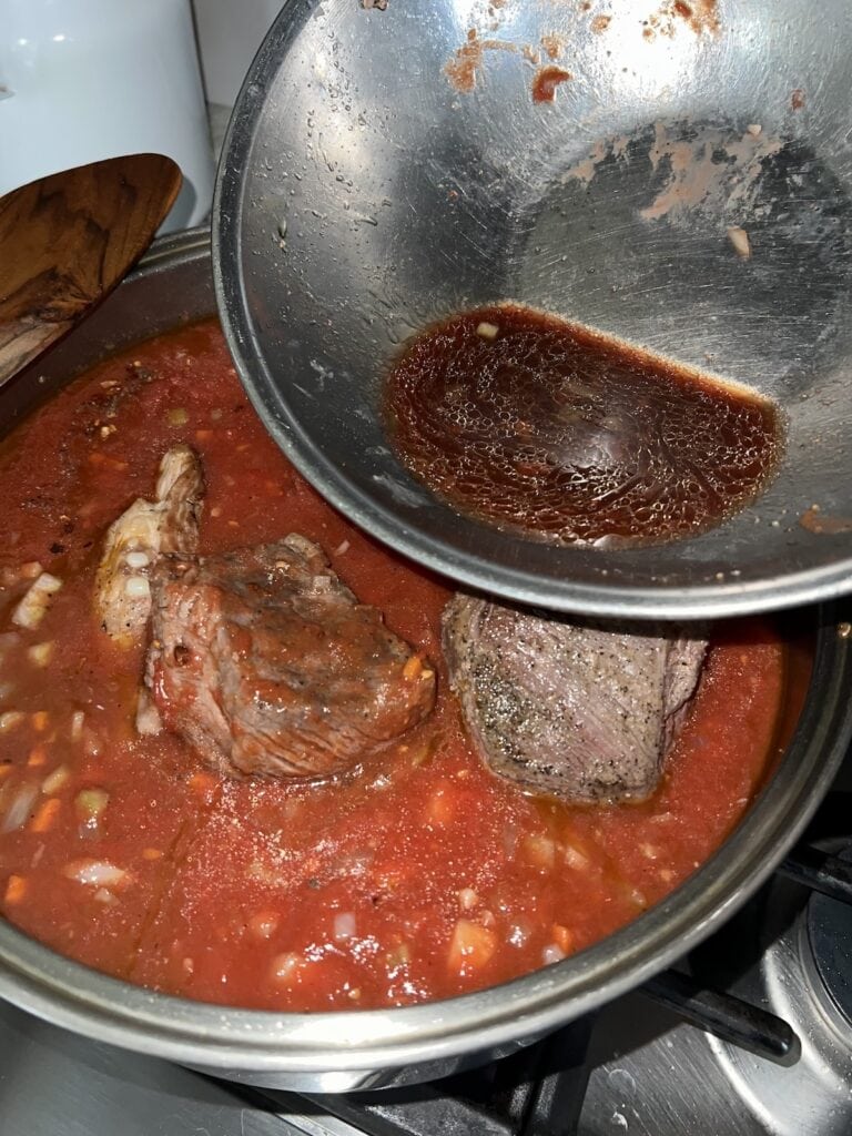 Meat juices being poured into the pot.