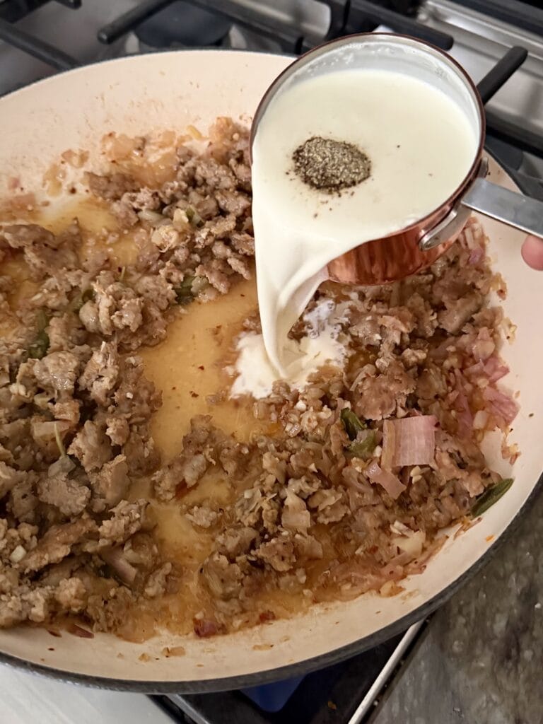 Pouring cream into pan for sauce.