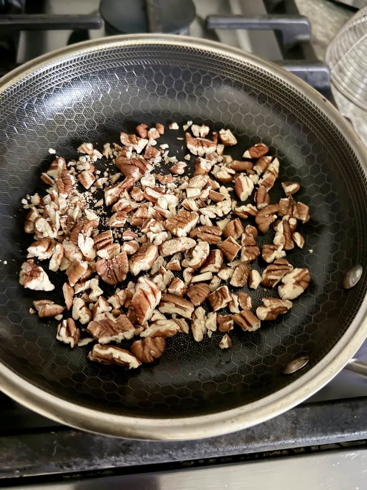 Toasting chopped pecans in pan.