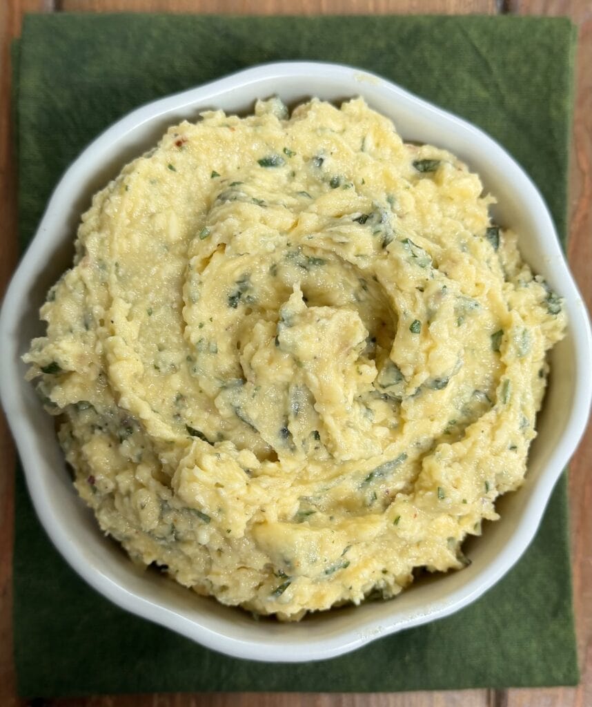 Finished garlic butter in bowl on top of a green towel.
