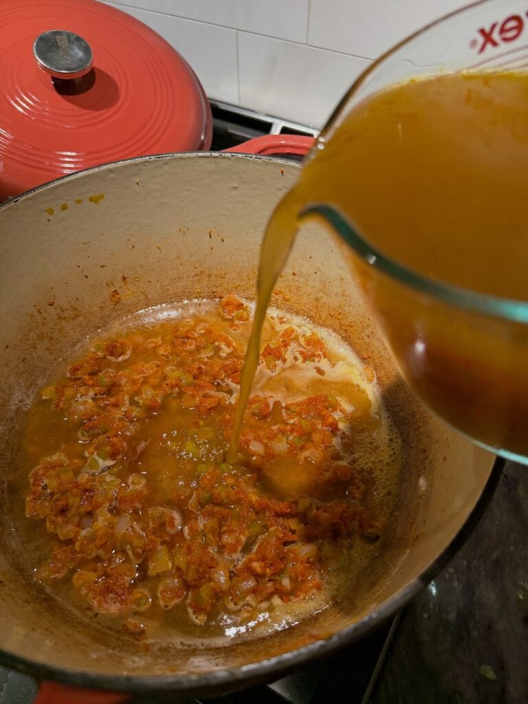 Pouring broth into pot.