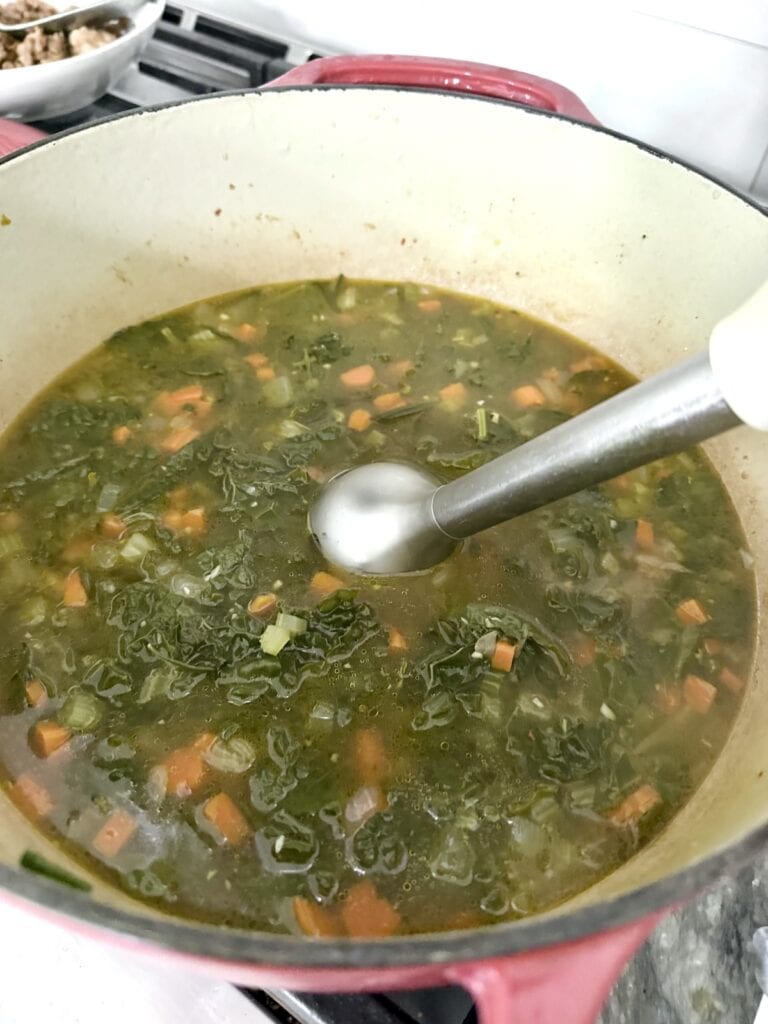 Using a hand blender to puree the gnocchi sausage soup.