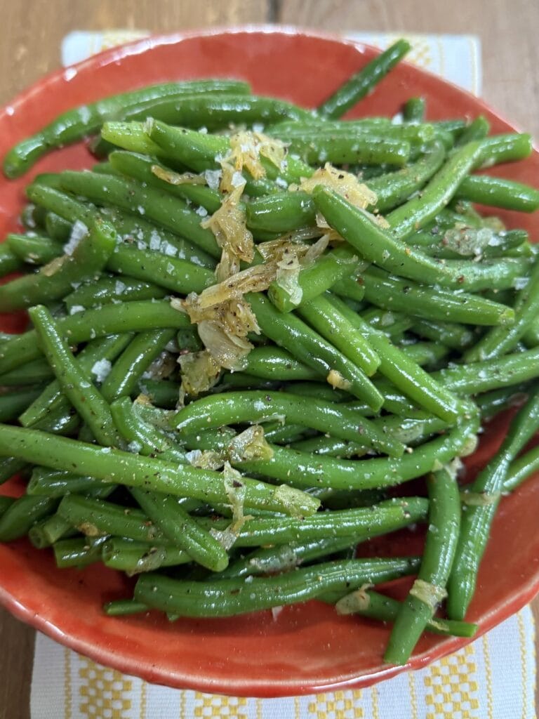 Sauteed String Beans in orange bowl.