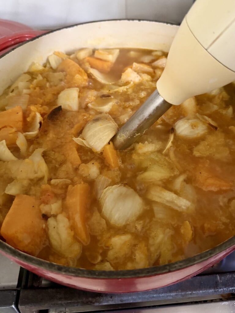 Pureeing contents of Dutch oven with immersion blender.
