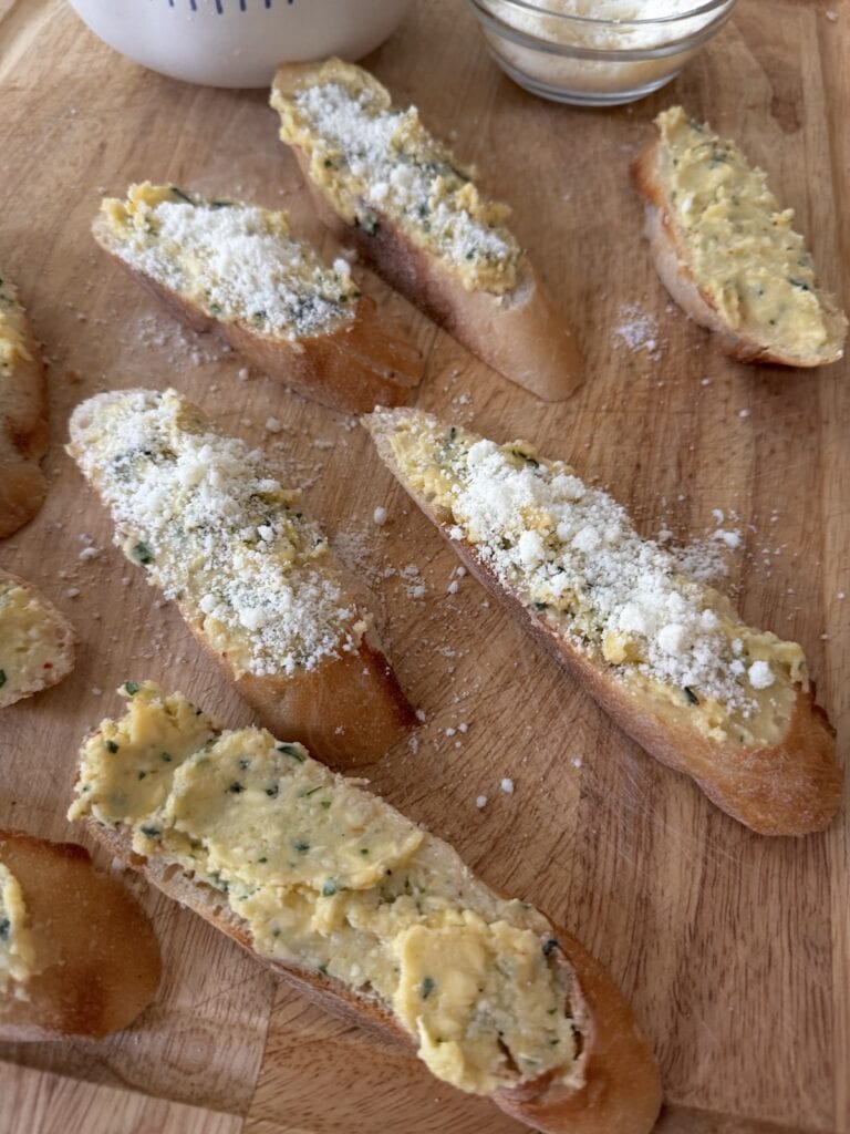 Buttered baguette slices ready to go into the oven