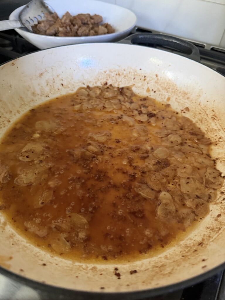The reduced wine in pan.