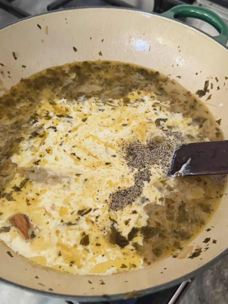 Mixing cream and black pepper into sauce.