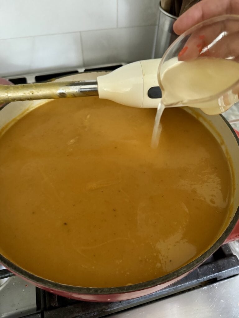 Pouring fresh lemon juice into soup.