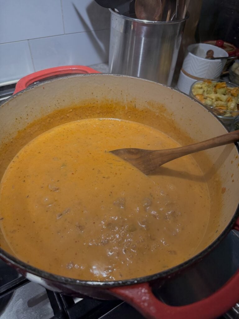 Stirring soup mixture with wooden spoon.