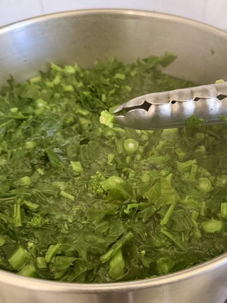 Using tongs to test if the stem is tender enough.
