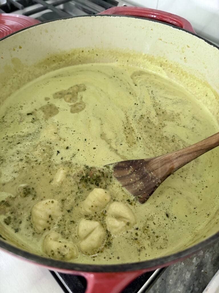 Stirring the soup with a wooden spoon.